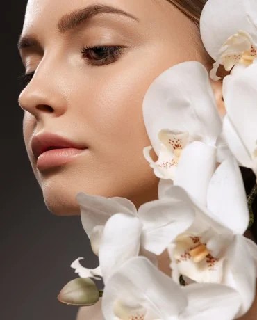 portrait beautiful young woman with nude make up posing with orchid flowers isolated dark background 1